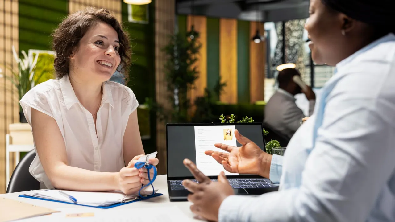 Service business professional consulting with a client at a desk with a laptop