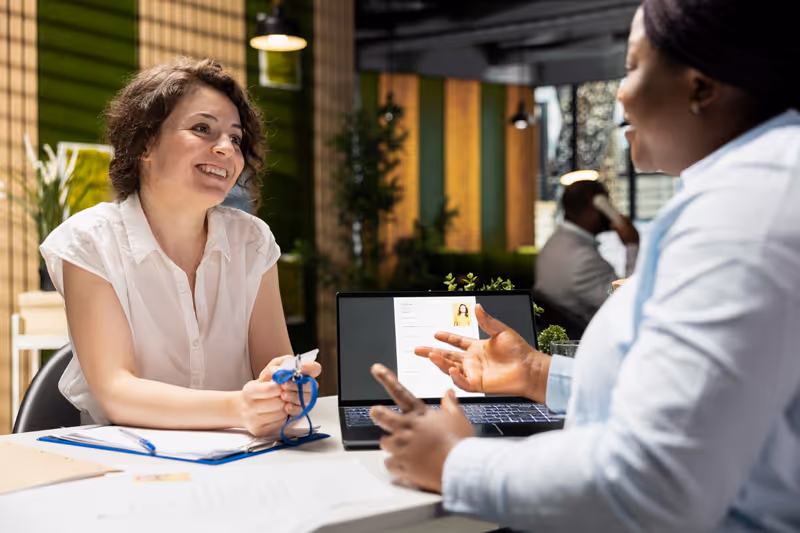 Service business professional consulting with a client at a desk with a laptop